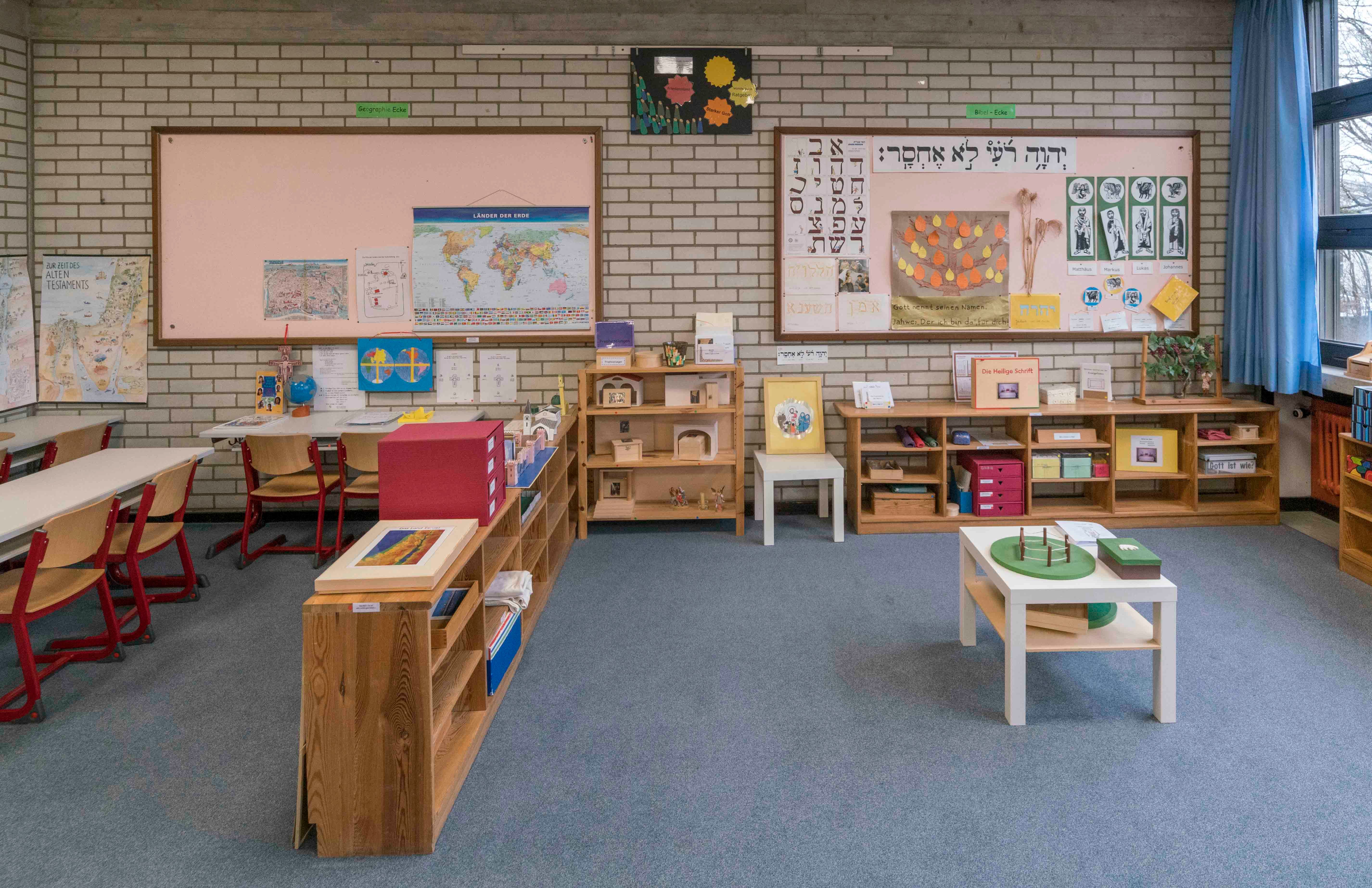 Klassenraum mit offenen Regalen mit Material zu verschiedenen Themen aus Bibel und Liturgie