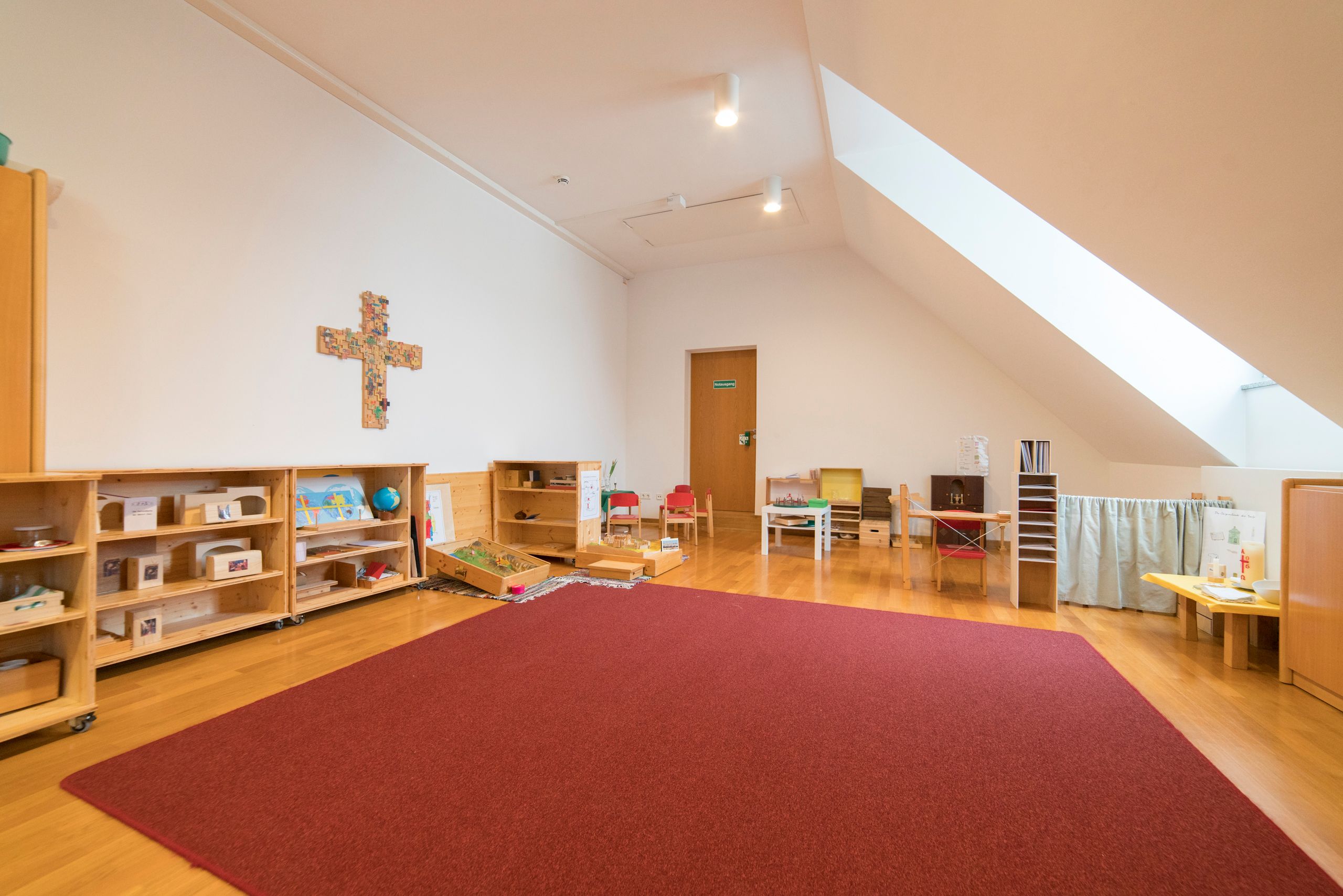 Ein Raum unter dem Dach mit hellem Tageslicht und offenen Regalen für die Materialien der Stufe I ist das Atrium Stufe I