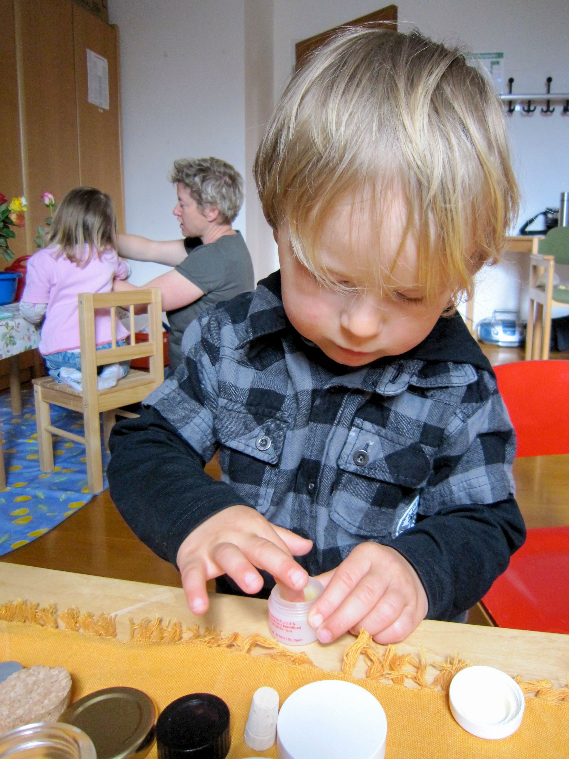 Ein kleiner Junge vertieft in eine Übung des täglichen Lebens