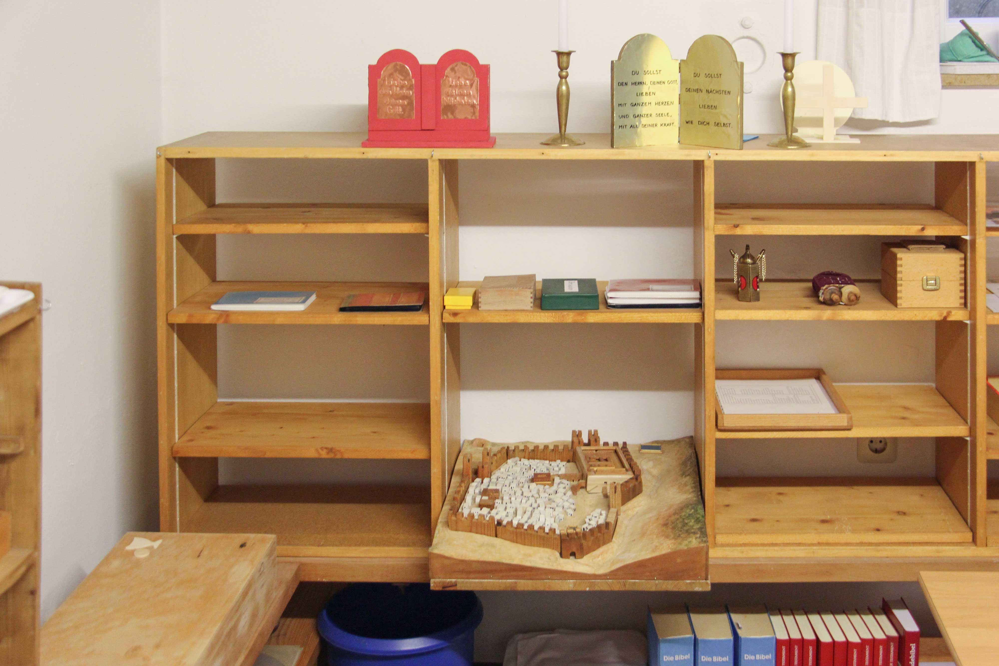 Offenes Regal mit dem Relief von Jerusalem und Materialien zur Bibel