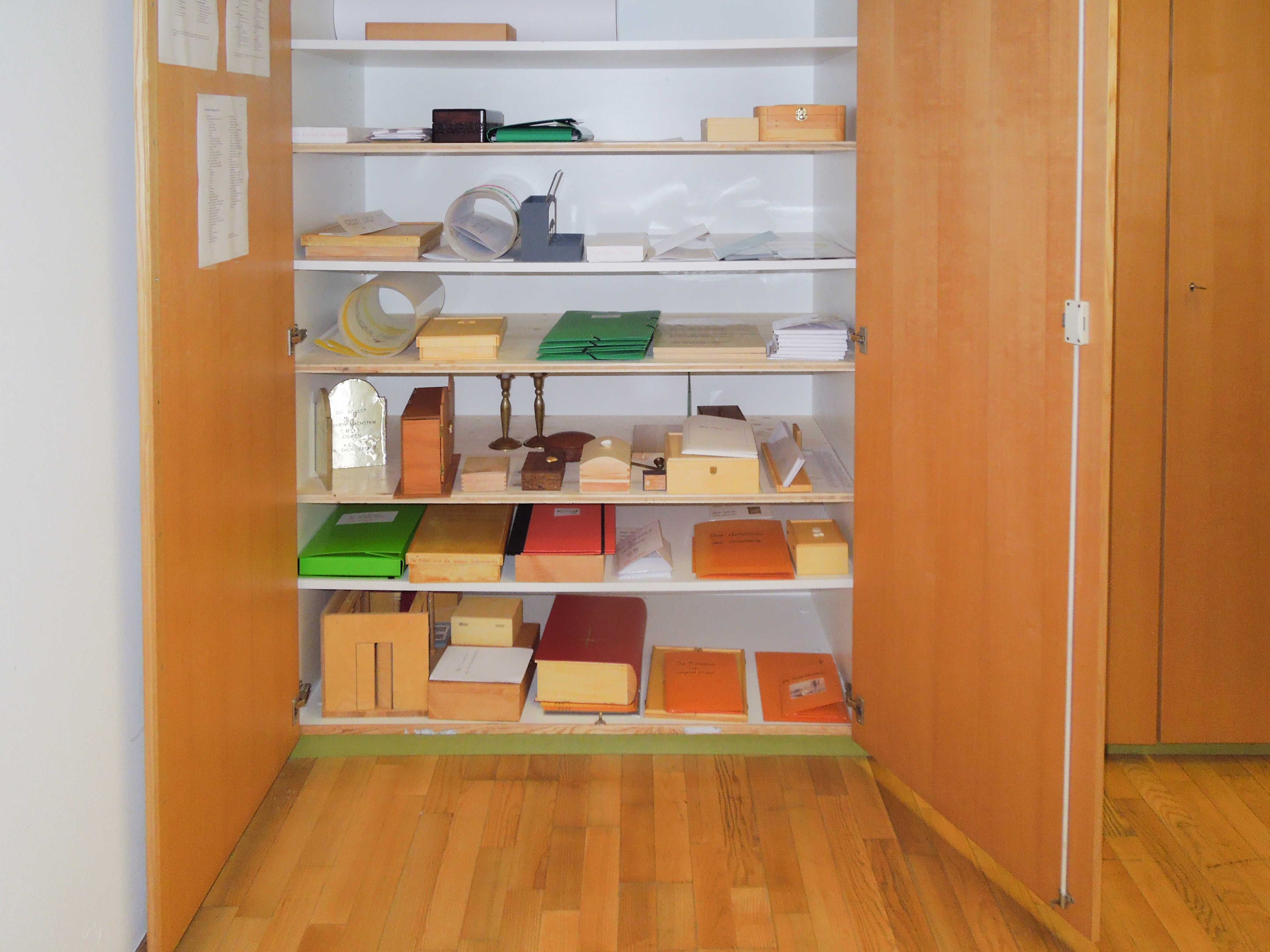 In einem geöffneten Schrank in einem Mehrzweckraum finden die Materialien der Stufe III ihren Platz und sind für die Kinder zugänglich.